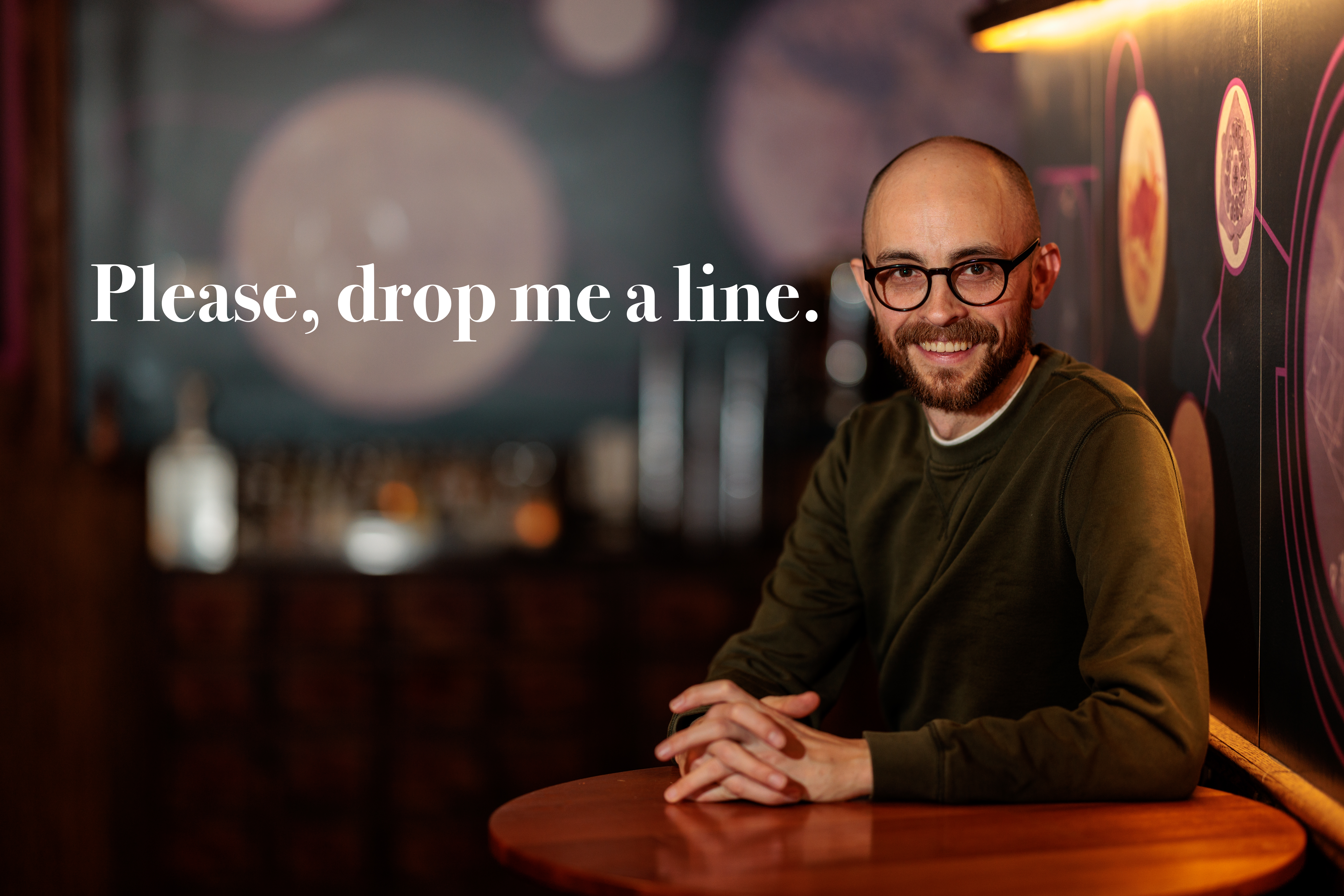 a strange, bald man with glasses, nearly forty years old, sits at a hightop table in a comedy club, beckoning you to contact him. in white text to the left of him, it reads, 'Please, drop me a line.' he begs, like a pathetic loser. a strange, bald man with glasses, nearly forty years old, sits at a hightop table in a comedy club, beckoning you to contact him. in white text to the left of him, it reads, 'Please, drop me a line.' he begs, like a pathetic loser.
